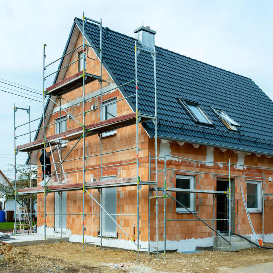 Ein Einfamilienhaus im Rohbau. Es ist von einem Baugerüst umgeben. Durch unsere Baubegleitung bei Bremen unterstützen wir Sie beim Hausbau.